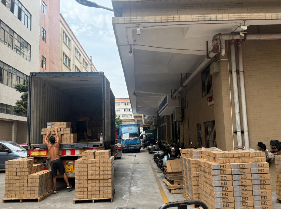 LED floodlight cartons being loaded into an export container at a lighting factory in China