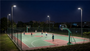 LED floodlights illuminating an outdoor basketball court at night